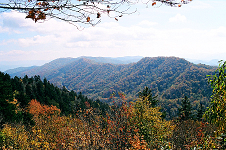 [Mountains on the left and right both go down to a valley (the gap). While there is a blue haze in the distance, there is much color on the trees at mid and close distances.]